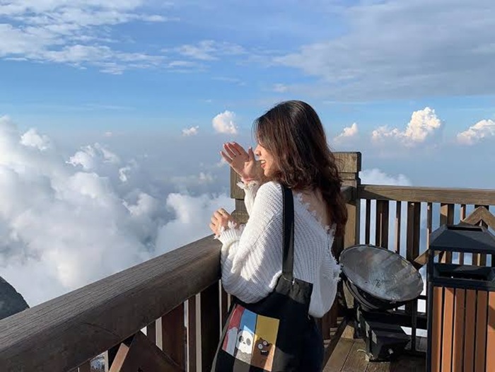 Du khách tạo dáng chụp ảnh ở đỉnh Fansipan - Ảnh: BestPrice