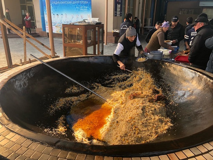 Một chảo plov được nấu trong khi chợ - ẩm thực Uzbekistan