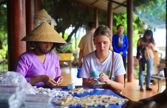 Du khách tự tay làm từng viên kẹo dừa quả là trải nghiệm thú vị và hào hứng - Ảnh: Internet