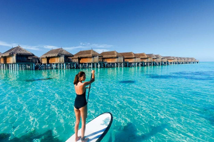 Kinh nghiệm du lịch Maldives - Du khách lướt sóng trên làn nước biển trong xanh