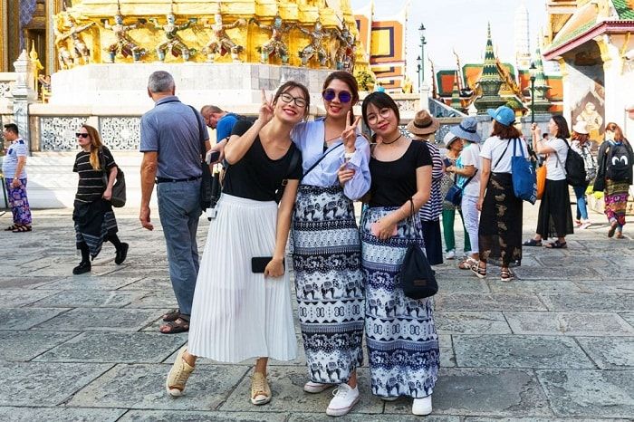 Kinh nghiệm đi chùa ở Thái Lan - Du khách quấn khăn sarong trước khi vào chùa